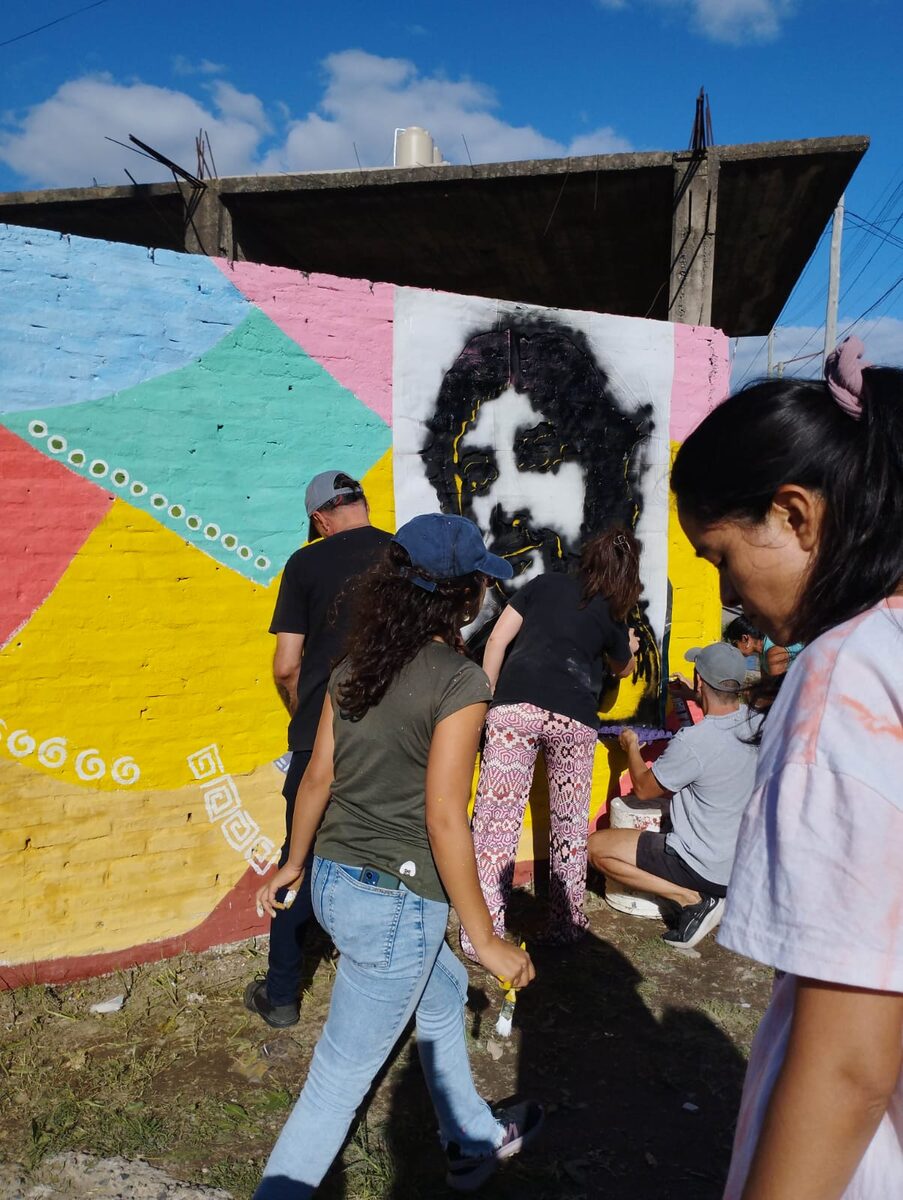 Docentes pintando el mural colectivo