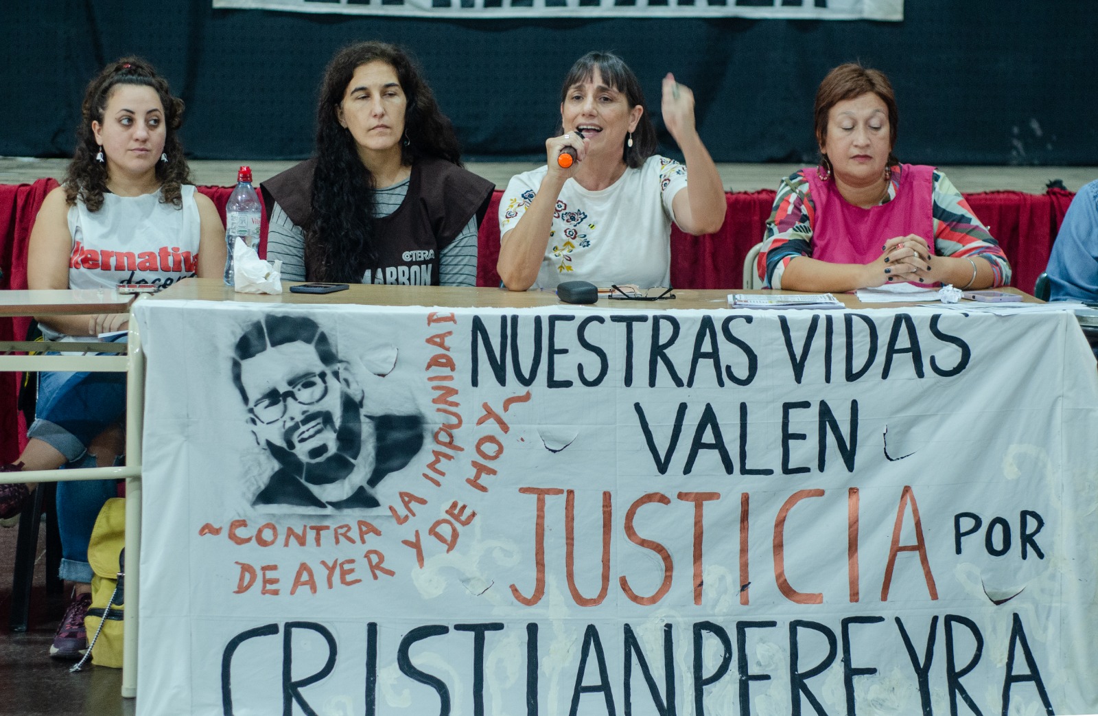 Oradoras en panel con cartel de Justicia por Cristian Pereyra de fondo