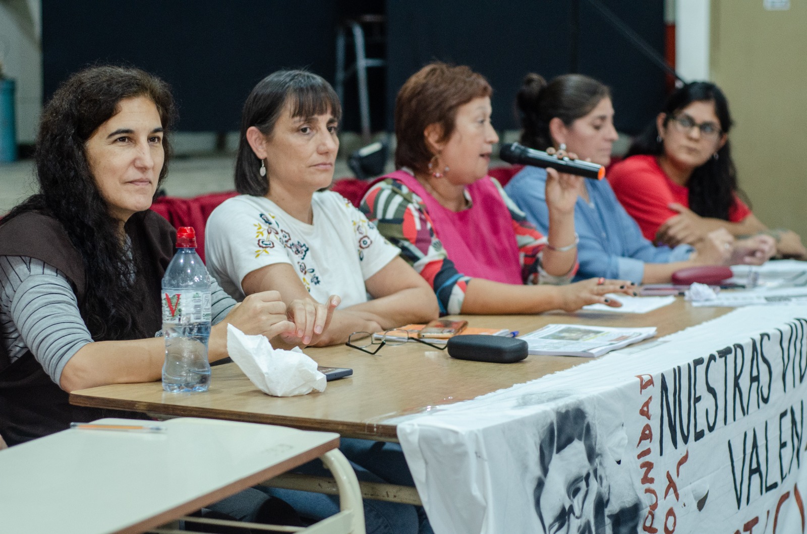 Docentes del Frente Multicolor en mesa de panel durante asamblea